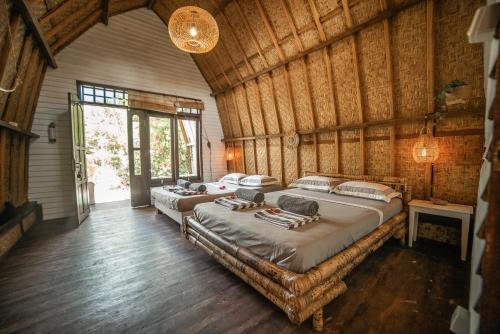 吉利阿尔Musa Villas and Bungalows Gili Air的木墙客房的两张床