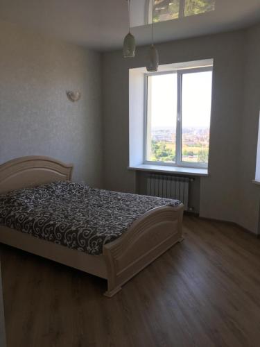 切尔诺莫斯克Квартира с видом на море的一间卧室设有一张床和两个窗户。