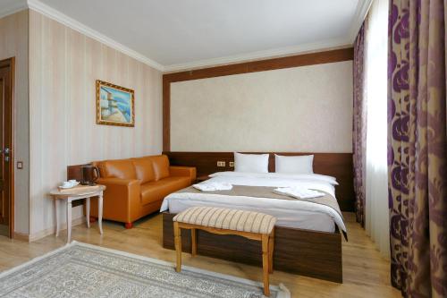 阿拉木图Sacvoyage Hotel的酒店客房,配有床和沙发
