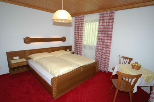 费尔兹姆斯福利恩古特拉肯霍夫酒店的一间卧室配有一张床和一张桌子及椅子