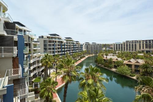 开普敦African Elite Waterfront的享有棕榈树和建筑的河流的空中景致