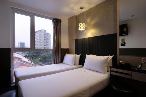 新加坡The Snooze Hotel at Bugis的配有窗户的酒店客房内的两张床