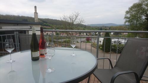 PalzemWeingut Edwin Pauly的阳台上配有带葡萄酒瓶和玻璃杯的桌子