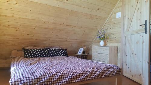 波加茨泽沃Mazurskie Ranczo的一间卧室设有一张床和木墙