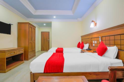 拜拉哈瓦Hotel Lacoul Inn的卧室配有带红色枕头的大型白色床
