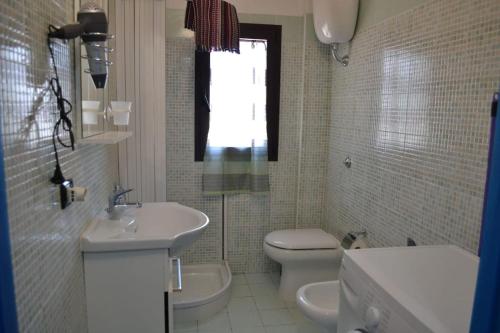 默塔玛丽亚Casa Vacanze Il Timone的一间带水槽和卫生间的浴室以及窗户。