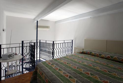 那不勒斯多米达摩酒店的一间卧室配有一张床和一张桌子,配有一张高潮床。