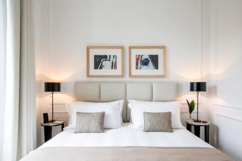 罗马Residenza B的一间卧室配有一张带两盏灯的大型白色床。
