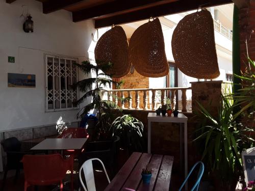 卡沃内拉斯Habitaciones Hernández的一间设有桌椅的餐厅,种植了植物