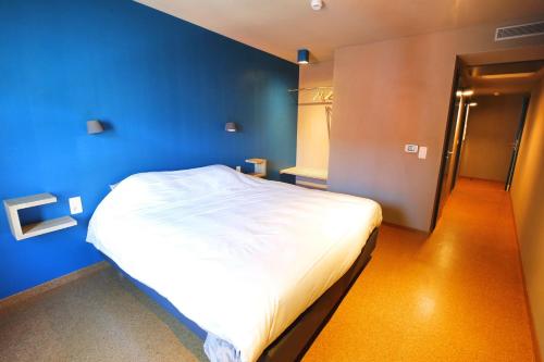 斯塔沃洛ô ChÔmière的一间卧室设有蓝色的墙壁和白色的床。