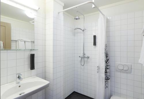 Fáskrúðsfjörður东部峡湾福斯酒店的带淋浴和盥洗盆的白色浴室