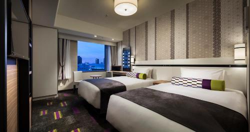 大阪大阪蒙特利勒费雷瑞酒店的酒店客房设有两张床和窗户。