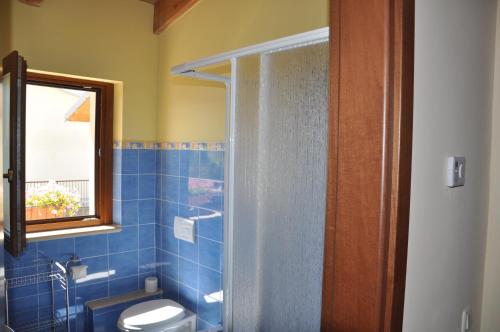 托尔托雷托Bed and Breakfast Latteletto的带淋浴、卫生间和窗户的浴室