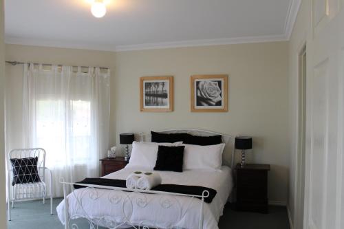 奥古斯塔Waterside View的卧室配有白色的床和黑白色枕头