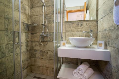 雅莎尼奥Aloni Studios & Apartments的一间带水槽和淋浴的浴室