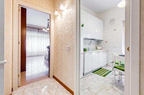 罗马J.N.D假日度假屋的厨房配有白色橱柜,门通往浴室