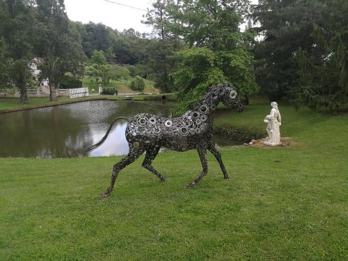 Lamothe-Montravelle jardin d Eau的池塘旁草丛中的马雕