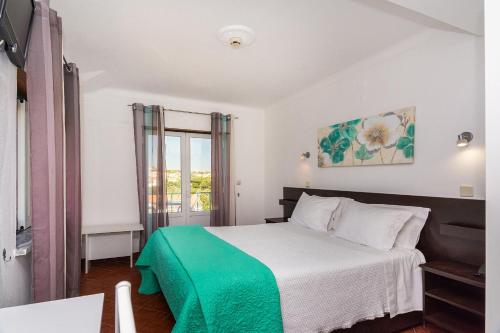 埃武拉格拉萨酒店 的一间卧室配有一张带绿毯的床