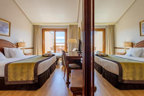 阿维拉埃克斯瑞纳伊莎贝尔酒店的酒店客房配有两张床和一张书桌