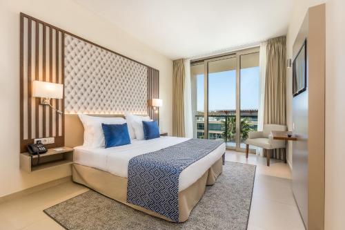阿尔布费拉NAU Salgados Dunas Suites的一间卧室配有一张带蓝色枕头的床