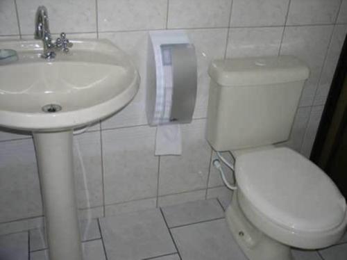 巴尔内阿里东海滩Hotel Pousada Mineirinho的浴室配有白色卫生间和盥洗盆。