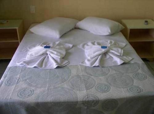 巴尔内阿里东海滩Hotel Pousada Mineirinho的床上铺有白色毛巾的床