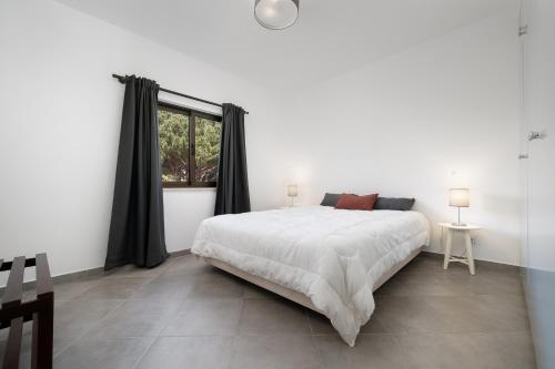 维拉摩拉Apartamento Moura Mar的白色的卧室设有一张大床和一个窗户