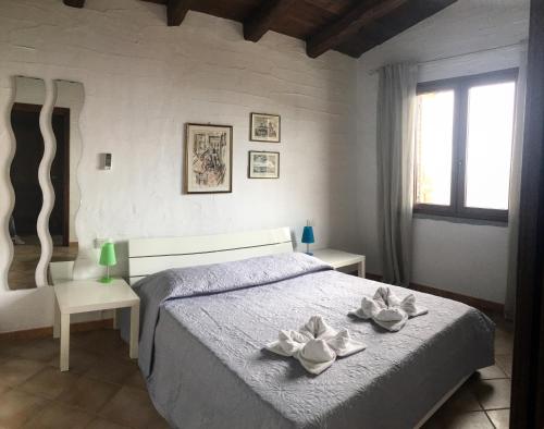 内比达L'Emozione Tanca Piras的一间卧室,床上放着两朵鲜花