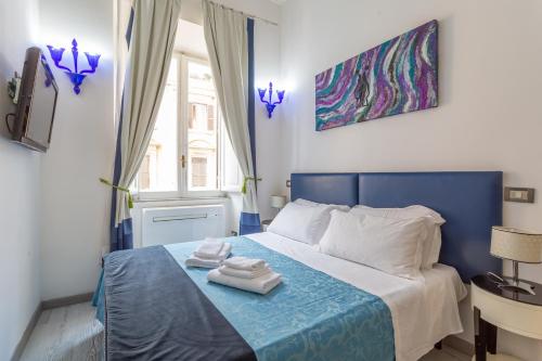 罗马White Vatican的一间卧室配有蓝色的床和毛巾