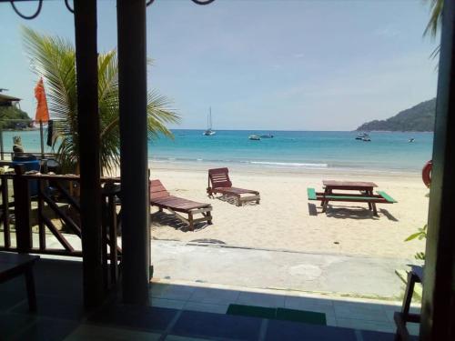 Kampong Juara朱拉海洋度假屋的享有海滩美景,配有椅子和桌子
