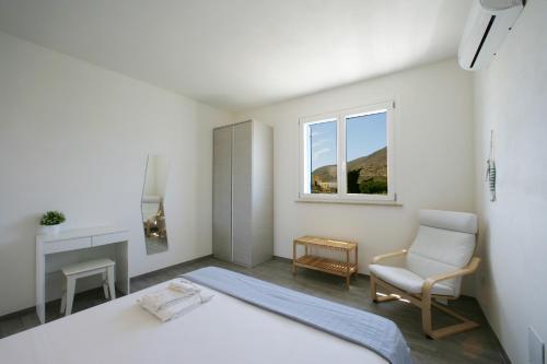 法维尼亚纳Corte della Cava的卧室配有床、椅子和窗户。