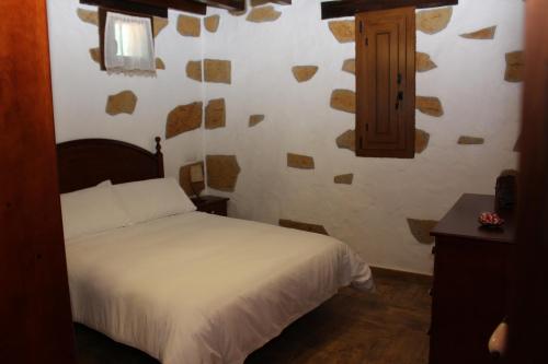 因赫尼奥Villa Cantos Colorados的卧室配有白色的床和木制橱柜。