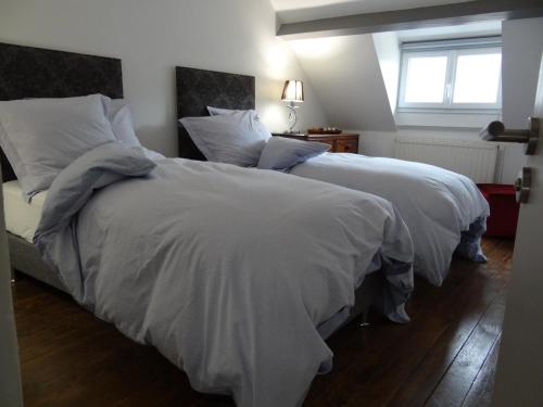贝叶Le 4的卧室内的两张床,配有白色的毯子和枕头