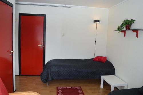 OlderdalenLyngenfjord, Frøyas hus的一间卧室设有一张床和一扇红色的门