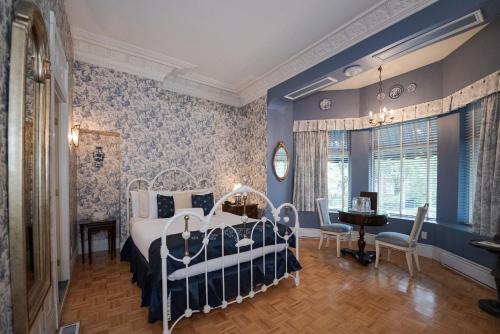 蒙特利尔舍布鲁克庄园酒店的卧室配有一张床和一张桌子及椅子
