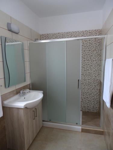 普罗塔拉斯Proteas Mare Suites的带淋浴、盥洗盆和镜子的浴室