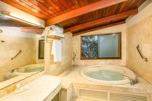 利马Decameron El Pueblo的带浴缸和盥洗盆的大浴室