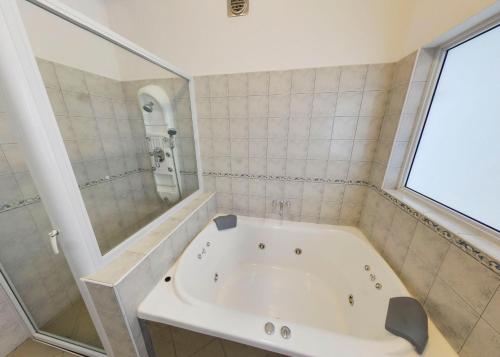 维拉卡洛斯帕兹Distrito Hotel的带窗户的浴室内的白色浴缸