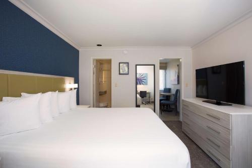洛杉矶圣莫尼卡啤可旅游宾馆的卧室配有一张白色大床和电视。