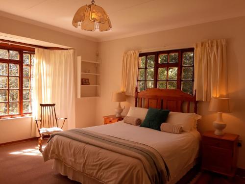 德尔斯特鲁姆Crane Cottage的一间卧室配有一张床、窗户和吊灯