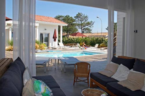 比斯卡罗斯海滩Côte et Dune的带沙发和游泳池的客厅