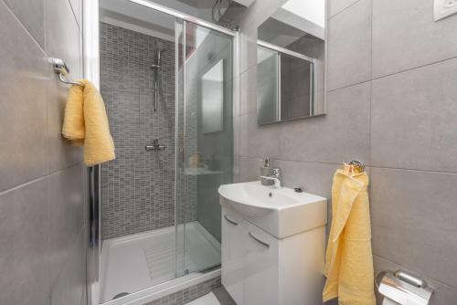 格拉达茨Tonka Apartments的带淋浴、盥洗盆和卫生间的浴室