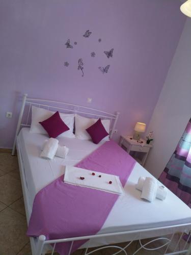 帕罗奇亚尼科莱塔客房酒店的卧室配有白色床、紫色床单和蝴蝶壁。