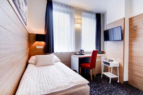 斯特拉科尼采Hotel Koflík的酒店客房配有一张床、一张书桌和一台电视。