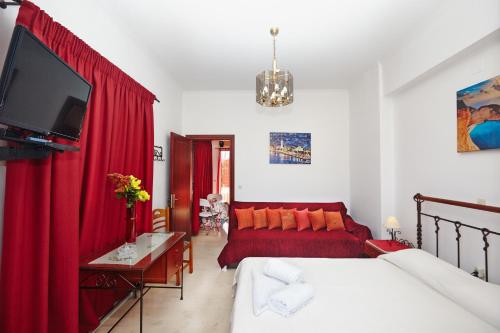 扎金索斯镇皮塔斯公寓的客厅配有红色窗帘和沙发