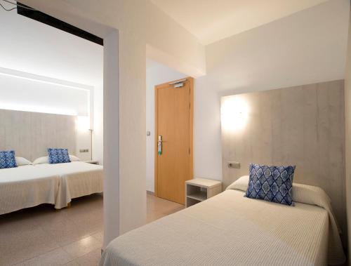 圣安东尼奥洛卡旅馆的一间卧室配有两张带蓝色枕头的床