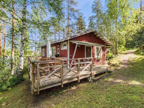 KylmäläHoliday Home Artturin mökki by Interhome的红色小屋,在树林里设有门廊