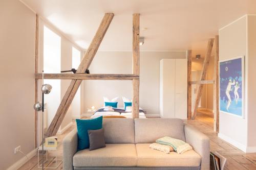塞巴特阿尔贝克OSTKÜSTE - Villa Albatros Design Apartments的客厅在床前设有沙发