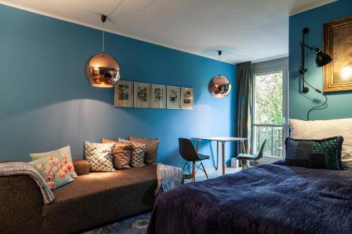 德累斯顿Studio Apartment in Dresden-Neustadt的卧室设有蓝色的墙壁、沙发和桌子