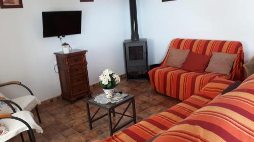 科尼尔-德拉弗龙特拉TRUJILLO HOLIDAY HOME con PISCINA的客厅配有沙发和桌子